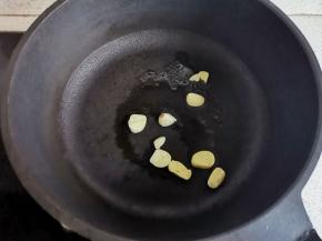 锅中热油，放入大蒜爆香。