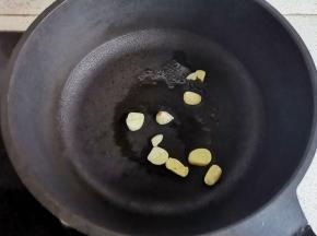 锅中热油，放入大蒜爆香。