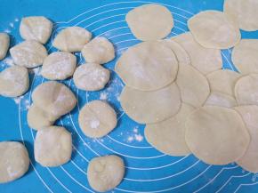 压扁擀成中间稍厚边缘薄的包子皮。