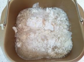 面包机桶内先加入中筋面粉，再加入混合好的发酵粉水。