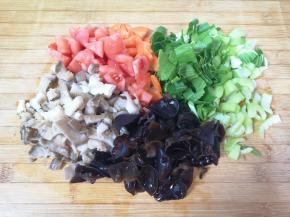 西红柿去皮切成小块，蘑菇洗干净切成小块，干木耳提前泡发，去根洗干净，青菜洗干净切碎。