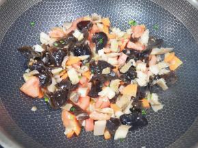 下入西红柿、蘑菇和木耳翻炒均匀。