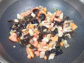 下入西红柿、蘑菇和木耳翻炒均匀。