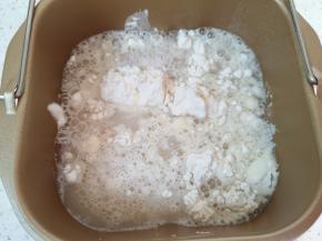 面包机桶内先加入中筋面粉，再加入混合好的发酵粉水。 