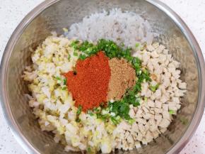 小葱切碎放入盆里，放上十三香和辣椒粉。 