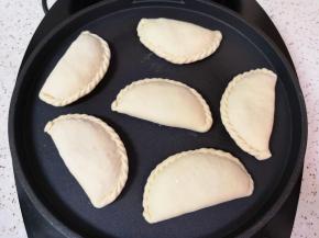 电饼铛上下盘预热，放入做好的菜盒，盖上电饼铛，选择“馅饼”功能启动。 