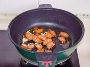 起油锅加入蒜末，辣椒段煸炒出香味，加腊肠翻炒。