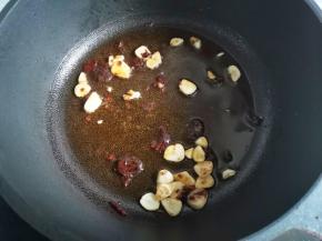 锅中入油，放入大蒜爆香，加一勺豆瓣酱炒出红油，