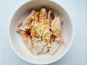 鸡翅加蒜末，一勺料酒，一勺生抽，半勺老抽，半勺盐，半勺糖，一勺黑胡椒抓匀腌制半小时。