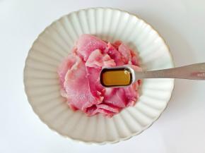 把猪肉放在盘里，加料酒一勺。