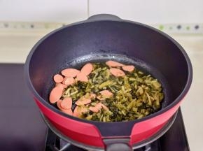 起油锅加入雪菜火腿片煸炒。