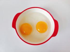 把两个鸭蛋打入碗里，加两勺清水【加水炒好的蛋更加嫩】