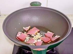 起油锅加入蒜末辣椒炒香，再加入腊肉翻炒。