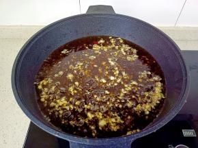 放入豆豉与蒜末小火继续慢慢煎。