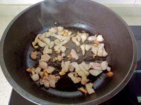 热锅热油下猪肉与蒜蓉爆香，煸出油脂。