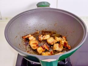 起油锅加入冰糖炒化至褐色，再加入煎过的五花肉翻炒。