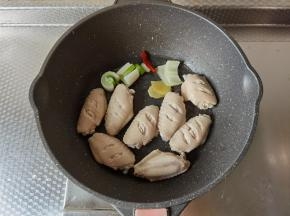 焯水后捞出冲洗干净沥干水分。不粘锅中倒入3勺玉米油，大火热油后，放入红辣椒，姜片、葱段爆香，然后排入鸡翅，开始煎。