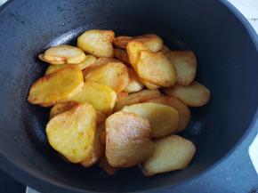 另起锅热油，放入全部煎好的土豆片，翻炒一分钟，