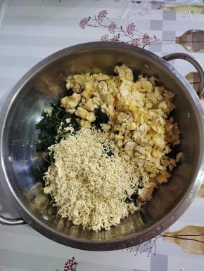 切好的荠荠菜放入盆中，放入鸡蛋米儿，再把一包方便面捏碎，放进去！（放方便面可以很好的把荠荠菜里面的水份吸干！）
