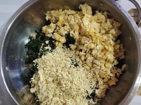 切好的荠荠菜放入盆中，放入鸡蛋米儿，再把一包方便面捏碎，放进去！（放方便面可以很好的把荠荠菜里面的水份吸干！）