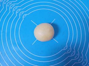 收口朝下摆放，用手掌轻轻压一下，一个豆沙馅喜饼就包好了，依次包完剩下的喜饼。 