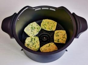 蒜香馒头片摆入空气炸锅炸篮中。