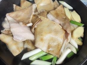 猪皮冷水下锅，放入葱段，姜片，适量的料酒，煮开，再继续煮10分钟左右！捞出！