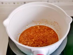 锅中热油，倒入蒜末，辣椒粉，白芝麻炒出香味。