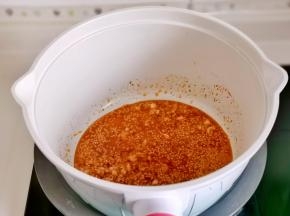 锅中热油，倒入蒜末，辣椒粉，白芝麻炒出香味。