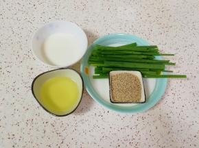 准备好玉米油、纯牛奶、白芝麻和香葱叶。 