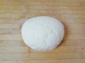 发酵好的面团从面包机里取出，揉成团。 