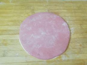 将两种不同颜色的面片摞起来，继续擀开。 