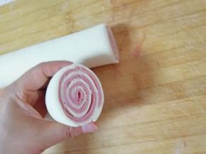 擀好的面片从一头卷起，从中间切开。 