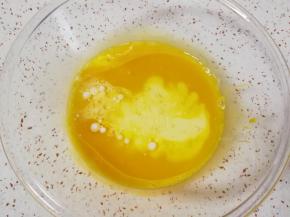 蛋黄用手动打蛋器搅打均匀，加入45g牛奶和45g玉米油。 