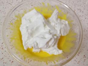 打发好的蛋白分成三份，取中间的三分之一加入到蛋黄糊里面，用硅胶刮刀翻拌均匀。
