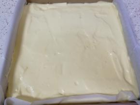 烤盘里铺上油纸，倒入蛋糕糊，用刮刀抹平，震出大气泡。 