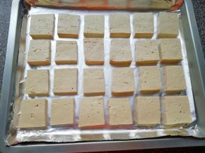 烤盘里铺上锡纸，将准备好的豆腐块摆在烤盘里。 