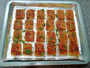 烤好的豆腐取出，趁热撒上香菜和白芝麻。 