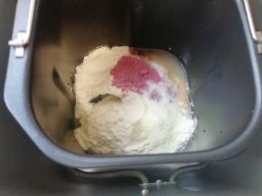 面包机桶内先加入水和全蛋液，接下来依次加入高筋面粉、紫薯粉、奶粉、盐和细砂糖，面粉中间挖个小洞放入干酵母，选择面包机的“自动和面”15分钟。 