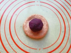 取一个面包面团压扁，放上紫薯馅包好收紧口。 