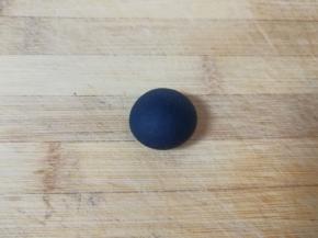 取8g左右的面团出来，加入少许竹炭粉揉成黑色的面团，用保鲜膜包上备用。