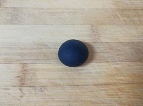 取8g左右的面团出来，加入少许竹炭粉揉成黑色的面团，用保鲜膜包上备用。