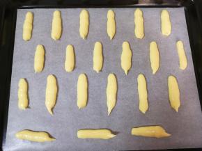 烤盘里铺上油纸，裱花袋剪一个不到1厘米的小口，将面糊挤成条状在油纸上，中间间距一定要留大一点，加热以后面糊就会变成薄饼状。