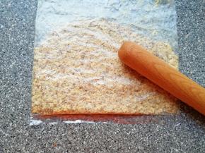 核桃仁装进保鲜袋，用擀面杖压碎。 