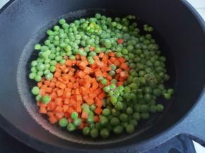锅中烧开水，放入豌豆胡萝卜丁煮2分钟。