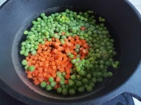锅中烧开水，放入豌豆胡萝卜丁煮2分钟。