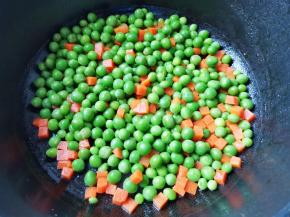锅内热油，加入豌豆胡萝卜，翻炒1分钟，