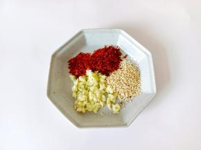 盘里放辣椒一勺，芝麻一勺，蒜一勺。