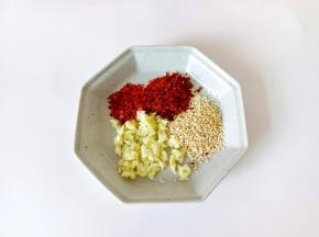 盘里放辣椒一勺，芝麻一勺，蒜一勺。