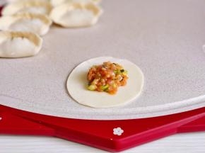 取一张饺子皮，放上馅儿。